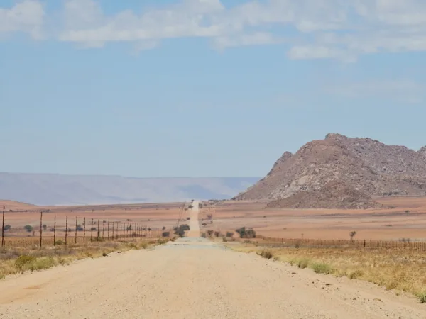 solitaria carretera de tierra conduciendo un Suzuki Jimny en Namibia